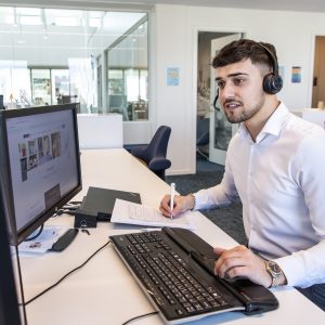 Mergim foran computer.