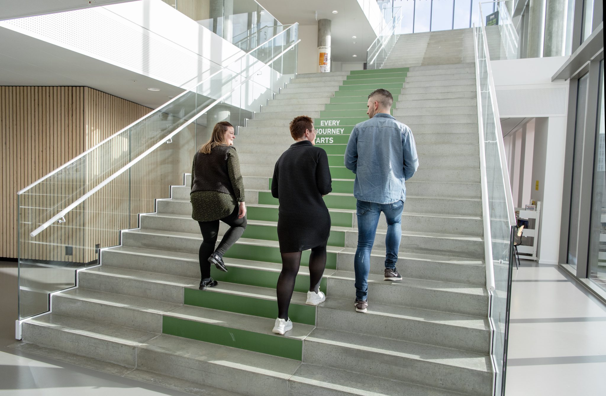 Tre personer går op ad trappen på IBA