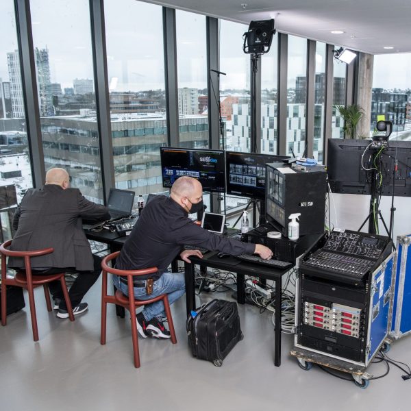 Billede af SEOday konferencen, der i 2021 blev holdt online. På billedet ses to mænd, der sidder og styrer konferencen fra deres computere.