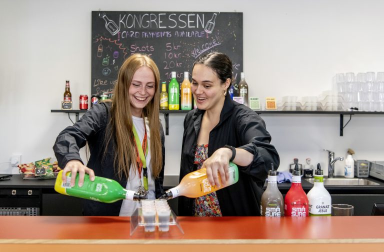 Studerende der står i baren i Kongressen og hælder shots op.