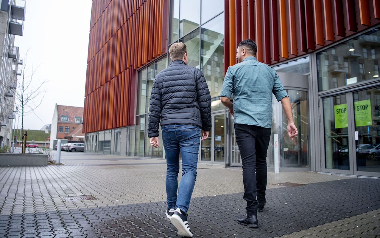 To studerende på vej ind af hovedindgangen på IBA.