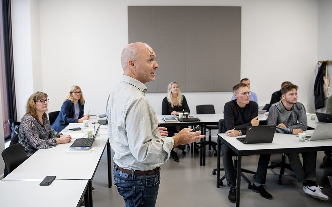 Underviser og studerende i et klasselokale.