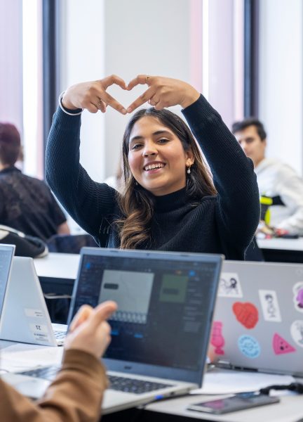 Studerende der laver hjerte med hænderne.