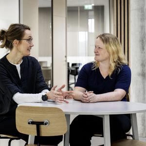 Laila og Maja ved et bord.