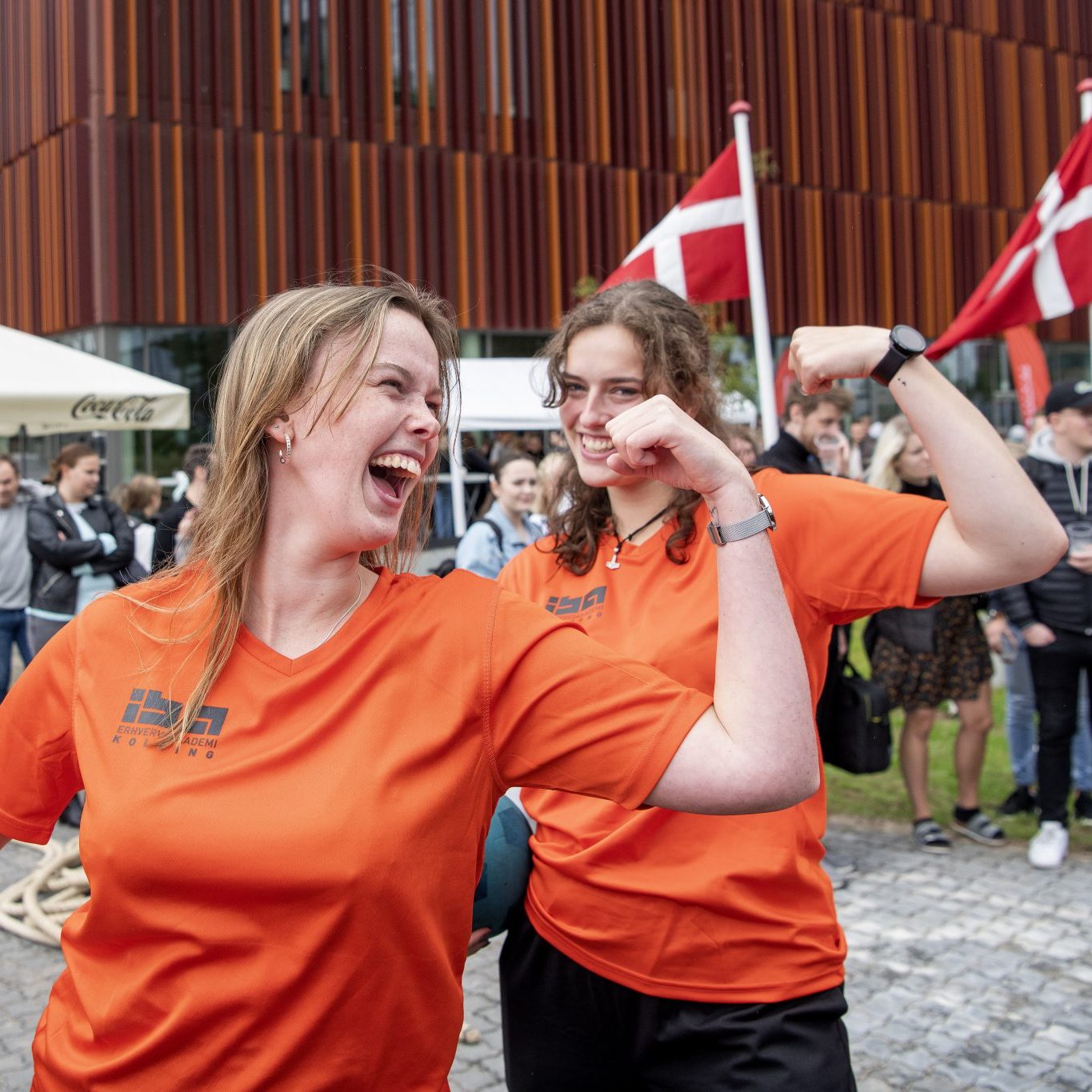 To studerende i orange IBA trøjer, der står på broen mellem IBA og SDU.
