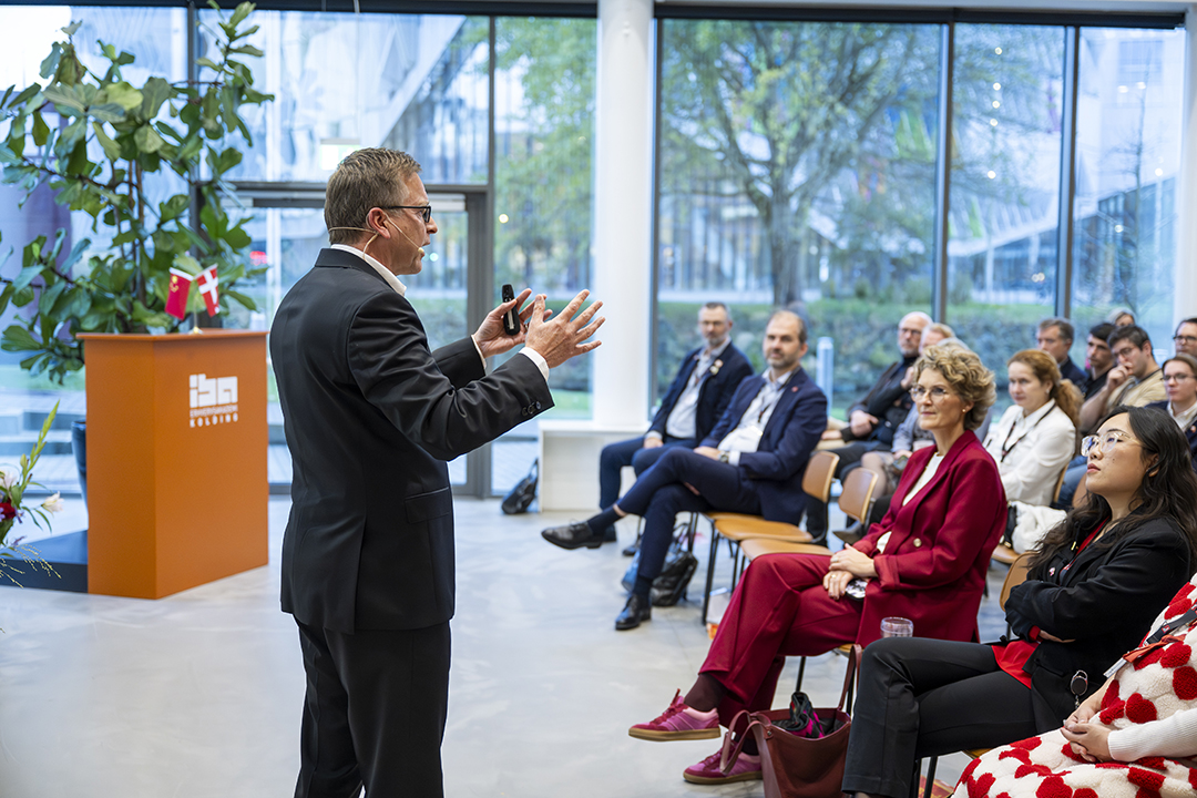 Mand giver tale til lyttende publikum