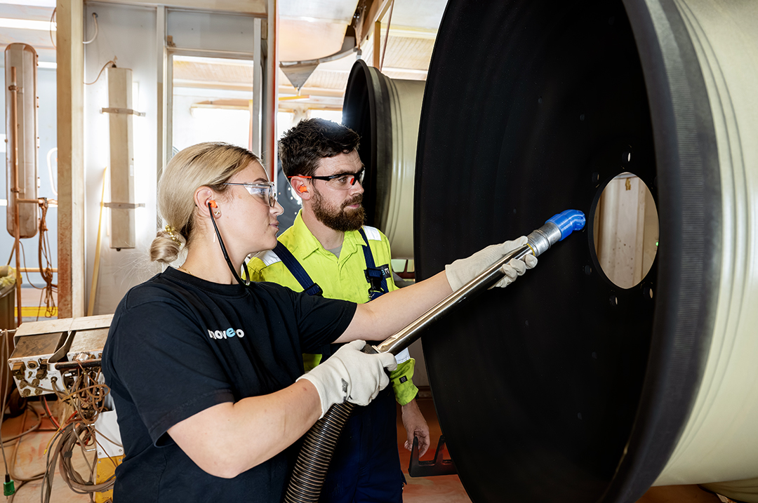 Foto af *Eleja, der står med et mundstykke til en maskine