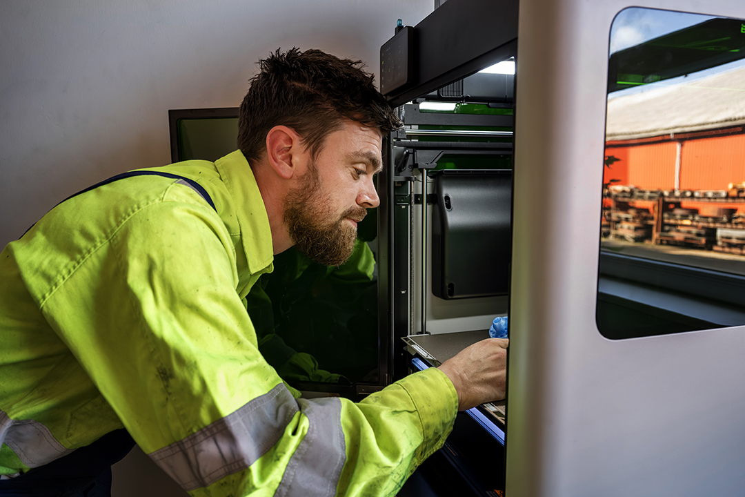 Foto af Philipp der kigger ind i en 3d-printer