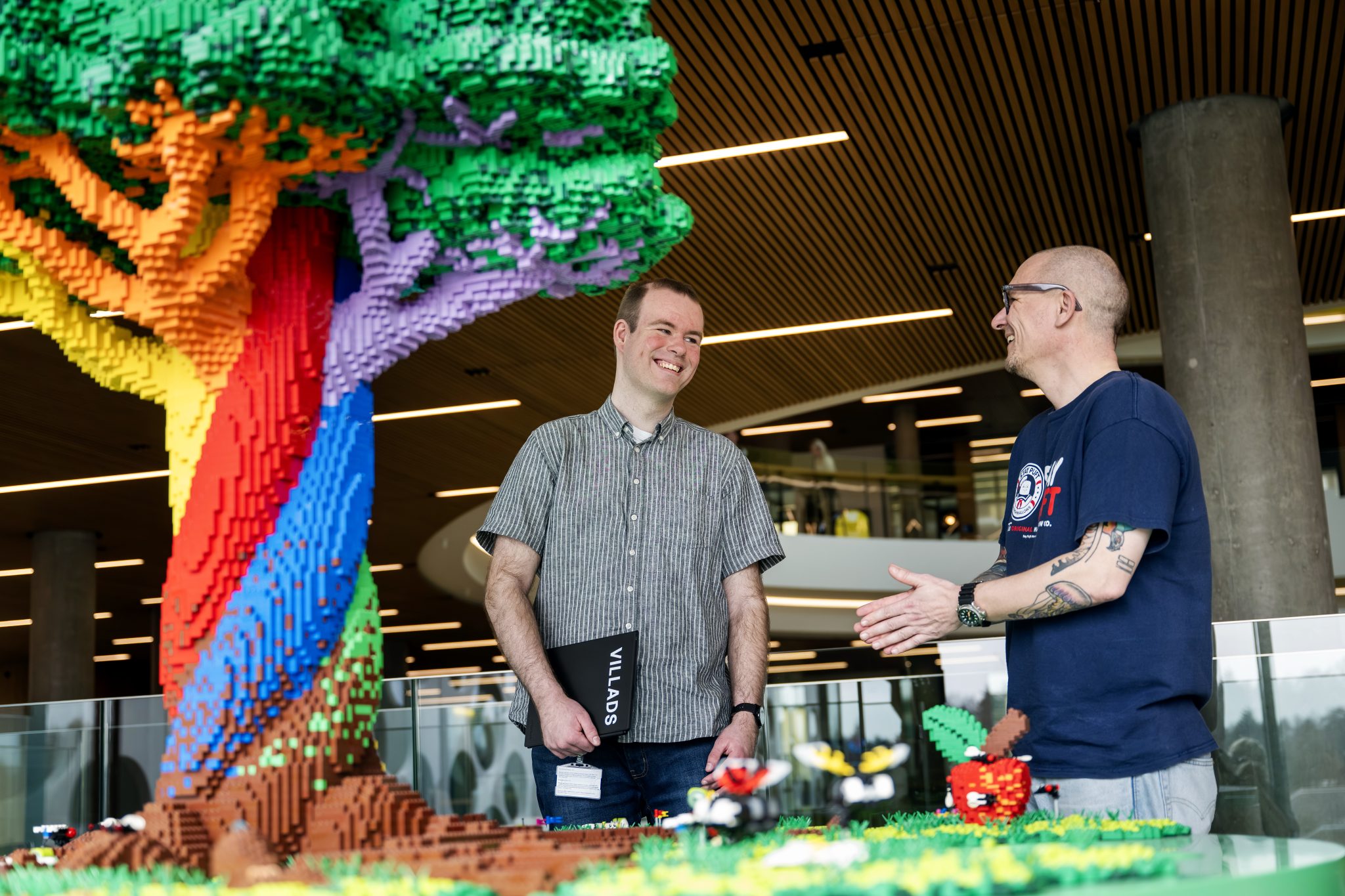 Villads Otto Rasmussen og kollega ved siden af stort LEGO træ hos LEGO i Billund.