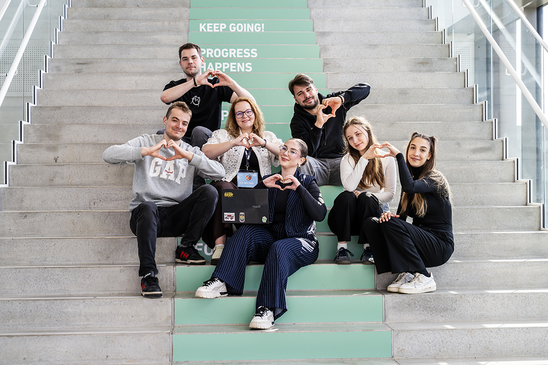 Foto af en flok studerende, der sidder på en af IBA's store indendørs trapper