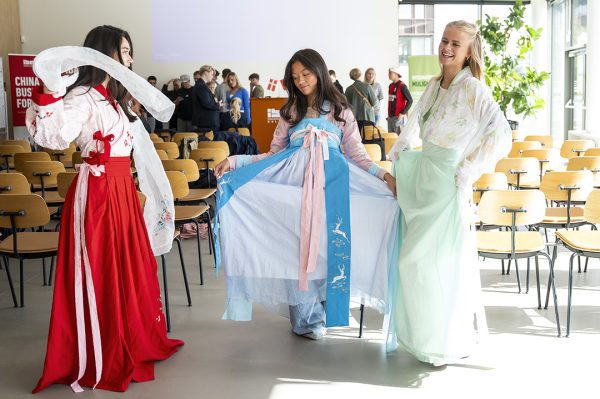 Foto af studerende, der står i traditionelt kinesisk tøj