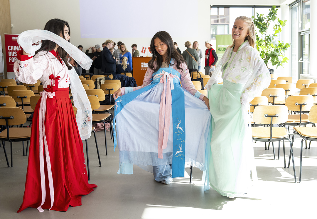 Foto af studerende, der står i traditionelt kinesisk tøj